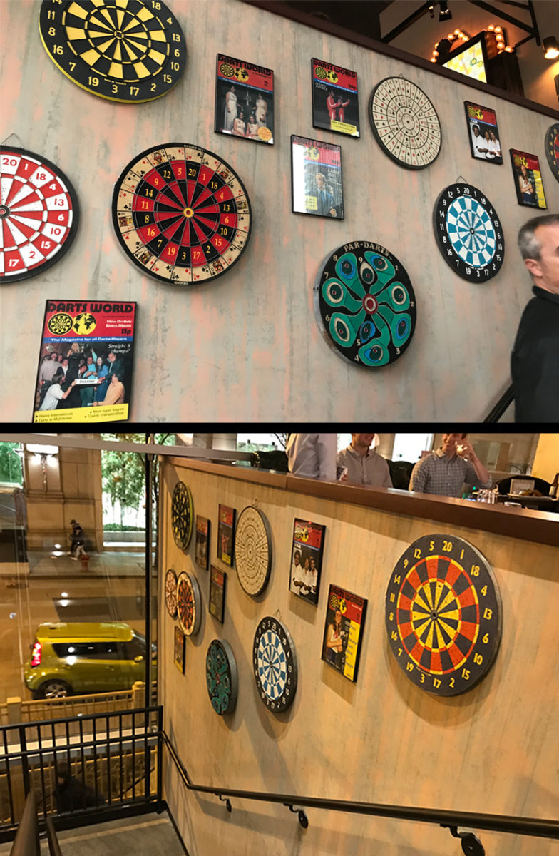 Playing steel tip darts at Flight Club Chicago. The walls surrounding the staircase that leads to the second floor, covered with unique dart memorabilia.